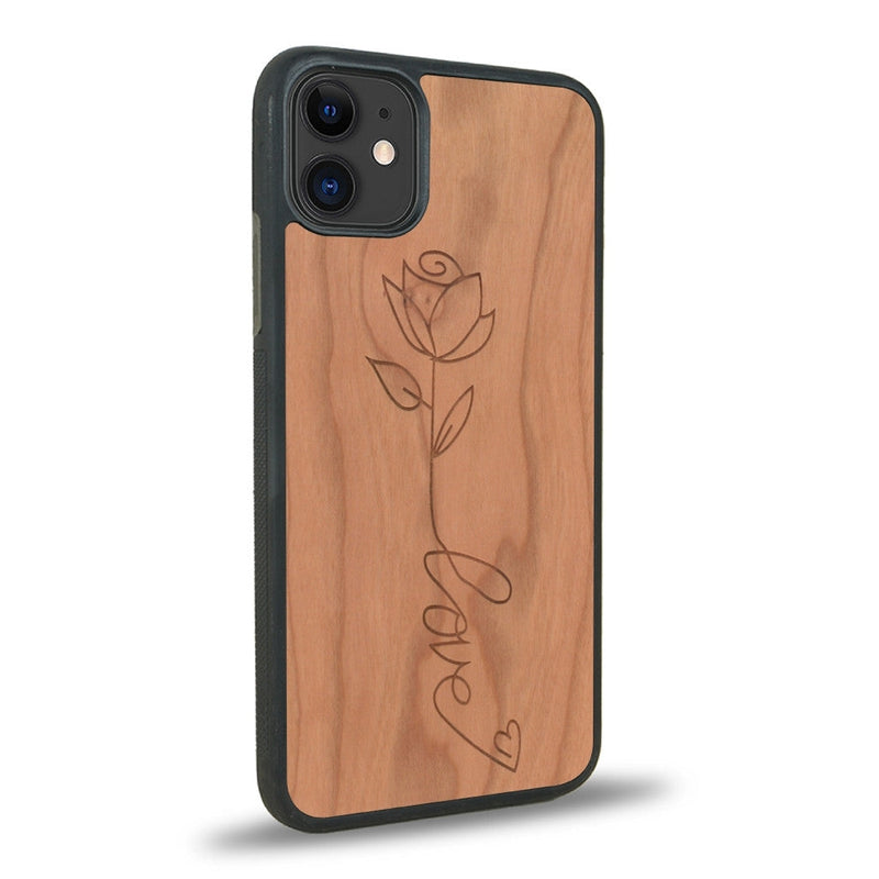 Coque de protection en bois véritable fabriquée en France pour iPhone 12 Mini sur le thème de la fête des mères avec un motif représentant une fleur dont la tige forme le mot "love"