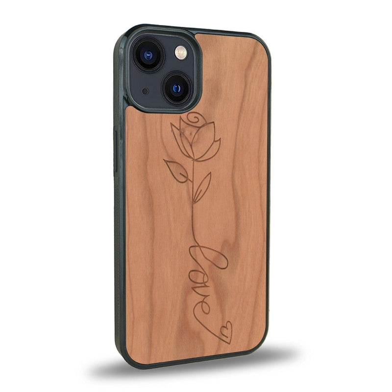 Coque de protection en bois véritable fabriquée en France pour iPhone 13 Mini + MagSafe® sur le thème de la fête des mères avec un motif représentant une fleur dont la tige forme le mot "love"