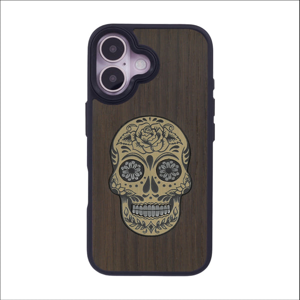 Coque de protection en bois véritable fabriquée en France pour iPhone 16 alliant du chêne fumé avec du métal argenté et doré représentant une tête de mort mexicaine sur le thème Dia de los Muertos