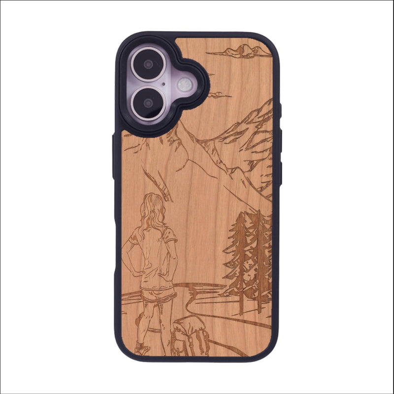 Coque de protection en bois véritable fabriquée en France pour iPhone 16 sur le thème de la randonnée en montagne et de l'aventure avec une gravure représentant une femme de dos face à un paysage de nature