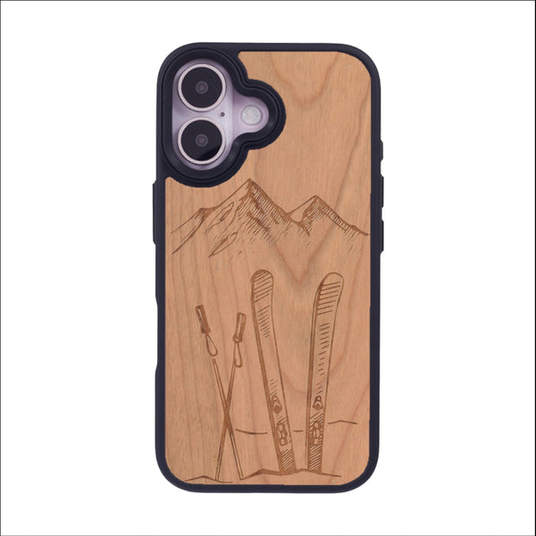 Coque de protection en bois véritable fabriquée en France pour iPhone 16 sur le thème de la montagne, du ski et de la neige avec un motif représentant une paire de ski plantée dans la neige avec en fond des montagnes enneigées