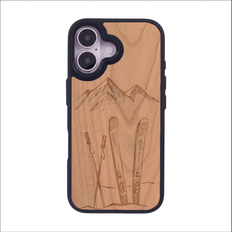 Coque de protection en bois véritable fabriquée en France pour iPhone 16 sur le thème de la montagne, du ski et de la neige avec un motif représentant une paire de ski plantée dans la neige avec en fond des montagnes enneigées