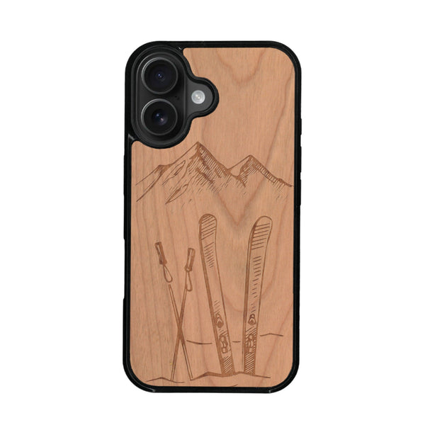 Coque de protection en bois véritable fabriquée en France pour iPhone 16 + MagSafe® sur le thème de la montagne, du ski et de la neige avec un motif représentant une paire de ski plantée dans la neige avec en fond des montagnes enneigées