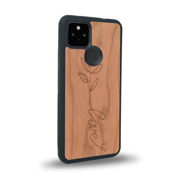 Coque de protection en bois véritable fabriquée en France pour Google Pixel 4a 5g sur le thème de la fête des mères avec un motif représentant une fleur dont la tige forme le mot "love"