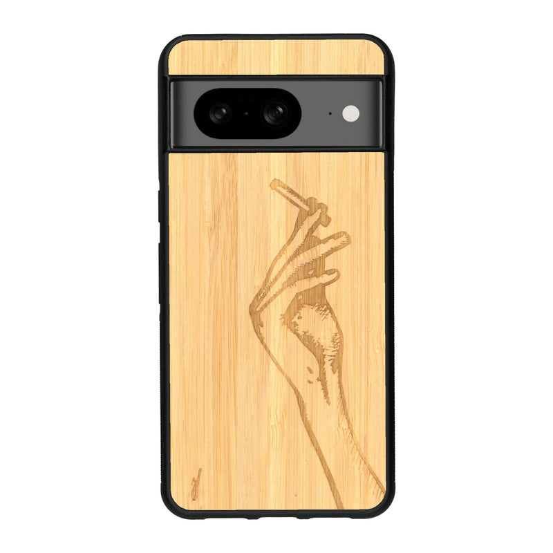 Coque de protection en bois véritable fabriquée en France pour Google Pixel 7A représentant une main de femme tenant une cigarette de type line art en collaboration avec l'artiste Maud Dabs