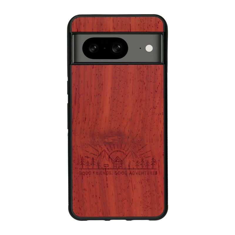 Coque de protection en bois véritable fabriquée en France pour Google Pixel 7A sur le thème chill et nature avec un motif représentant un levé de soleil sur un paysage de montagne avec des sapins et un chalet et la phrase "Good friends, good adventure"