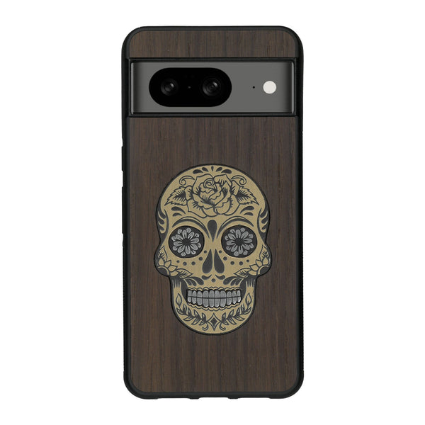 Coque de protection en bois véritable fabriquée en France pour Google Pixel 8A alliant du chêne fumé avec du métal argenté et doré représentant une tête de mort mexicaine sur le thème Dia de los Muertos