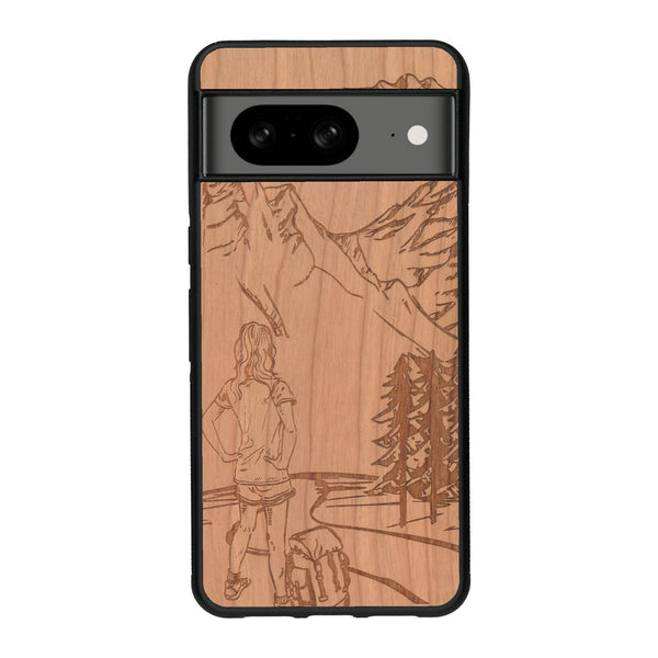 Coque de protection en bois véritable fabriquée en France pour Google Pixel 8A sur le thème de la randonnée en montagne et de l'aventure avec une gravure représentant une femme de dos face à un paysage de nature