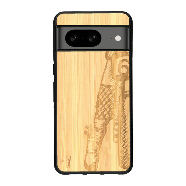 Coque de protection en bois véritable fabriquée en France pour Google Pixel 8A représentant une vue de face d'une femme sur une moto vintage dessinée à la main par l'artiste Maud Dabs