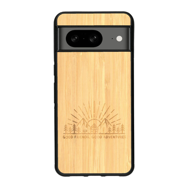 Coque de protection en bois véritable fabriquée en France pour Google Pixel 8A sur le thème chill et nature avec un motif représentant un levé de soleil sur un paysage de montagne avec des sapins et un chalet et la phrase "Good friends, good adventure"