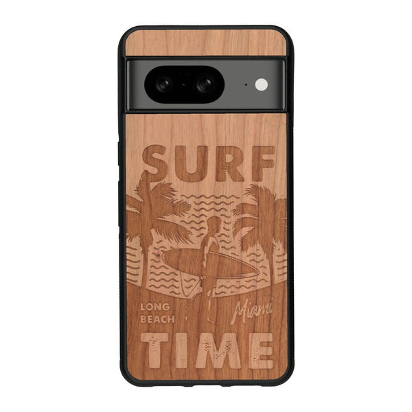 Coque de protection en bois véritable fabriquée en France pour Google Pixel 8A sur le thème chill avec un motif représentant une silouhette tenant une planche de surf sur une plage entouré de palmiers et les mots "Surf Time Long Beach Miami"