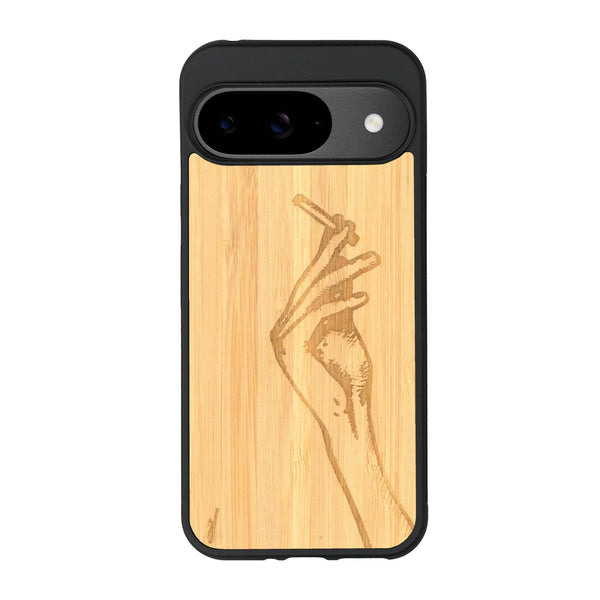 Coque de protection en bois véritable fabriquée en France pour Google Pixel 8A représentant une main de femme tenant une cigarette de type line art en collaboration avec l'artiste Maud Dabs