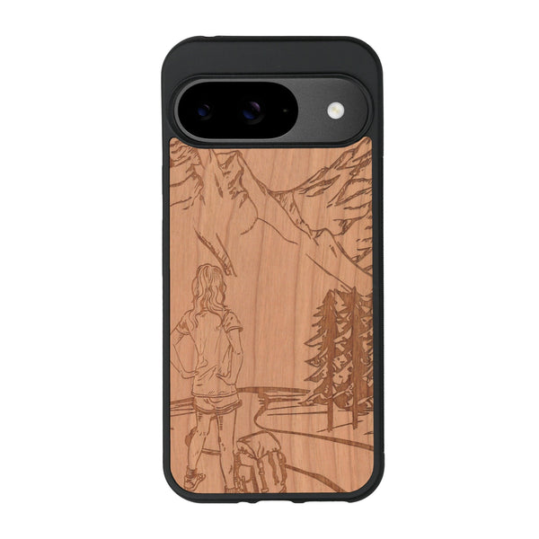 Coque de protection en bois véritable fabriquée en France pour Google Pixel 9 sur le thème de la randonnée en montagne et de l'aventure avec une gravure représentant une femme de dos face à un paysage de nature