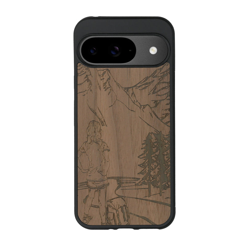 Coque de protection en bois véritable fabriquée en France pour Google Pixel 9 sur le thème de la randonnée en montagne et de l'aventure avec une gravure représentant une femme de dos face à un paysage de nature