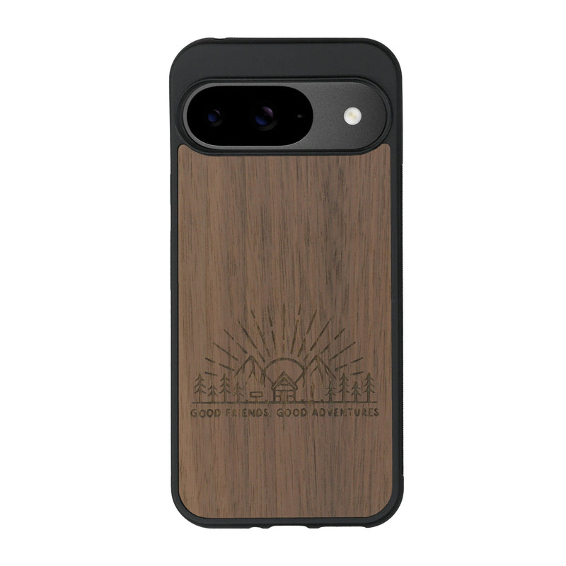 Coque de protection en bois véritable fabriquée en France pour Google Pixel 9 Pro sur le thème chill et nature avec un motif représentant un levé de soleil sur un paysage de montagne avec des sapins et un chalet et la phrase "Good friends, good adventure"