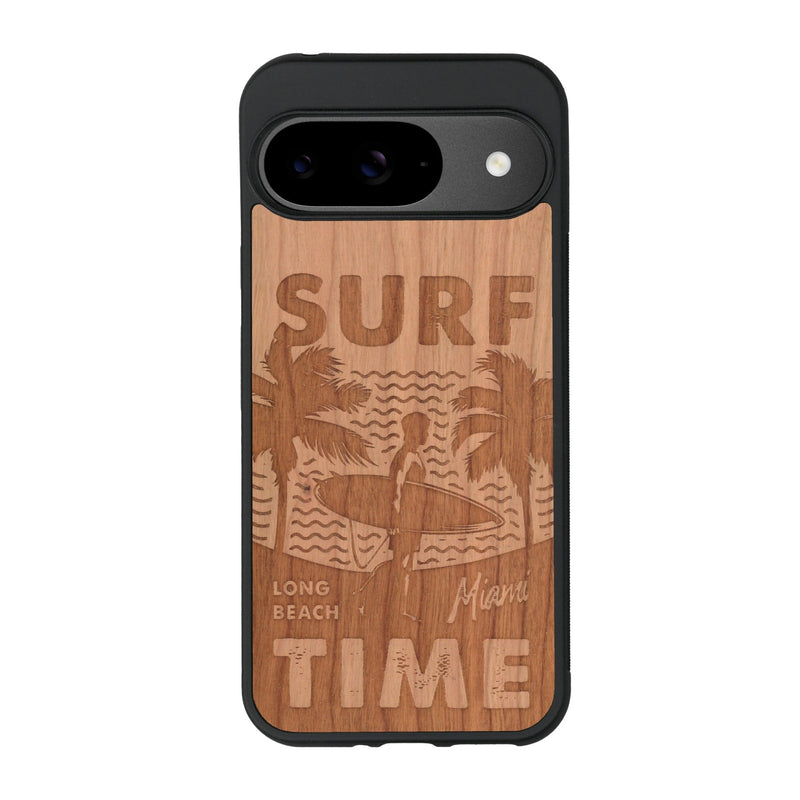 Coque de protection en bois véritable fabriquée en France pour Google Pixel 9 Pro sur le thème chill avec un motif représentant une silouhette tenant une planche de surf sur une plage entouré de palmiers et les mots "Surf Time Long Beach Miami"