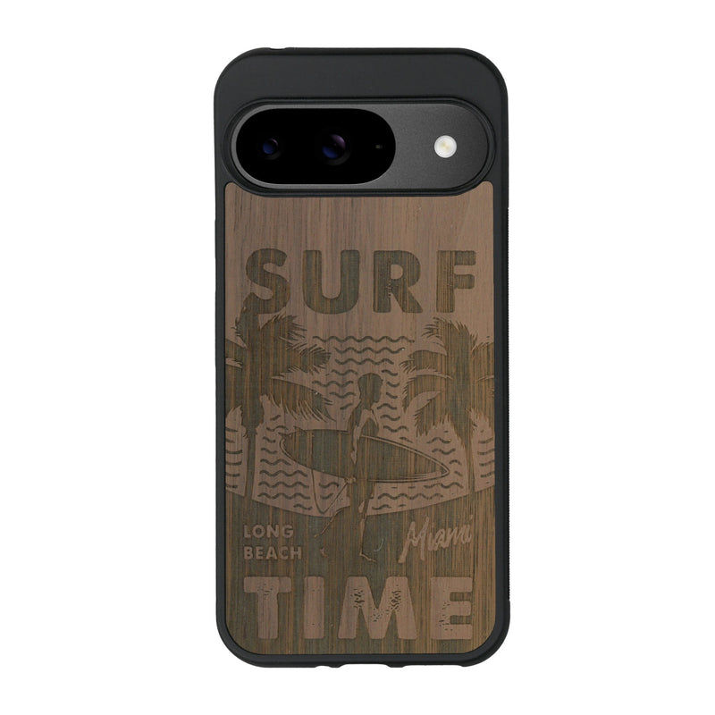 Coque de protection en bois véritable fabriquée en France pour Google Pixel 9 Pro sur le thème chill avec un motif représentant une silouhette tenant une planche de surf sur une plage entouré de palmiers et les mots "Surf Time Long Beach Miami"