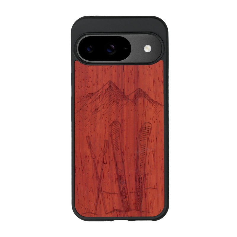 Coque de protection en bois véritable fabriquée en France pour Google Pixel 9 Pro sur le thème de la montagne, du ski et de la neige avec un motif représentant une paire de ski plantée dans la neige avec en fond des montagnes enneigées