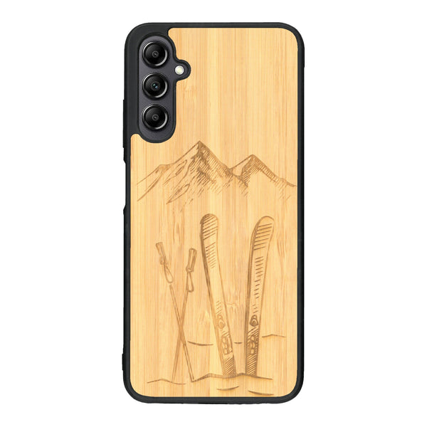 Coque de protection en bois véritable fabriquée en France pour Samsung A14 sur le thème de la montagne, du ski et de la neige avec un motif représentant une paire de ski plantée dans la neige avec en fond des montagnes enneigées