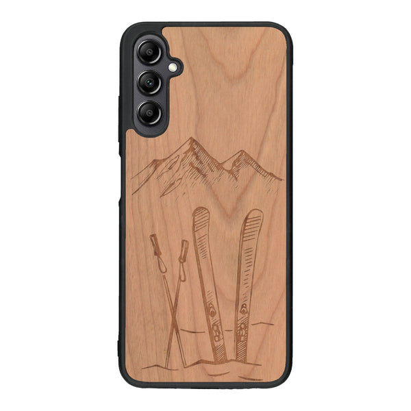 Coque de protection en bois véritable fabriquée en France pour Samsung A14 sur le thème de la montagne, du ski et de la neige avec un motif représentant une paire de ski plantée dans la neige avec en fond des montagnes enneigées