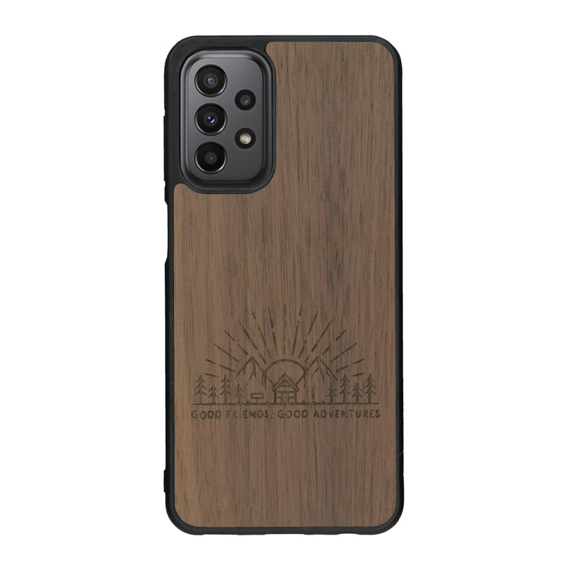 Coque de protection en bois véritable fabriquée en France pour Samsung A33 sur le thème chill et nature avec un motif représentant un levé de soleil sur un paysage de montagne avec des sapins et un chalet et la phrase "Good friends, good adventure"