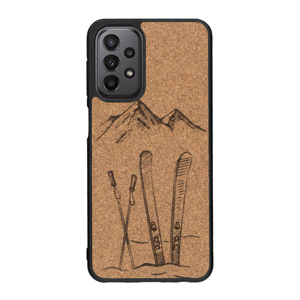 Coque de protection en bois véritable fabriquée en France pour Samsung A33 sur le thème de la montagne, du ski et de la neige avec un motif représentant une paire de ski plantée dans la neige avec en fond des montagnes enneigées