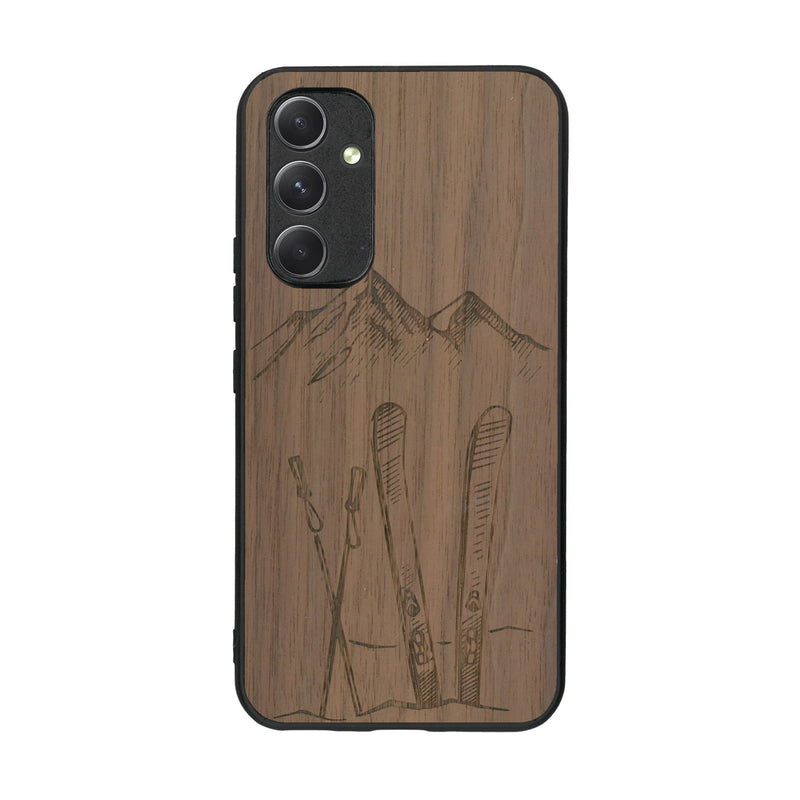 Coque de protection en bois véritable fabriquée en France pour Samsung A54 5G sur le thème de la montagne, du ski et de la neige avec un motif représentant une paire de ski plantée dans la neige avec en fond des montagnes enneigées