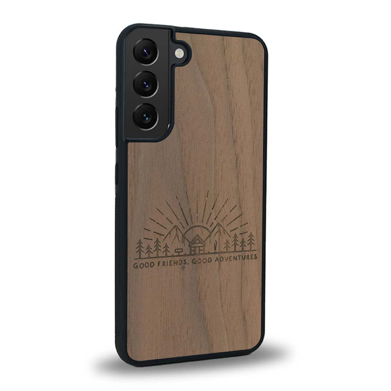 Coque de protection en bois véritable fabriquée en France pour Samsung S24 sur le thème chill et nature avec un motif représentant un levé de soleil sur un paysage de montagne avec des sapins et un chalet et la phrase "Good friends, good adventure"