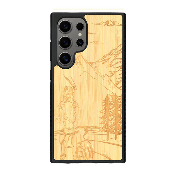 Coque de protection en bois véritable fabriquée en France pour Samsung S24 Ultra sur le thème de la randonnée en montagne et de l'aventure avec une gravure représentant une femme de dos face à un paysage de nature