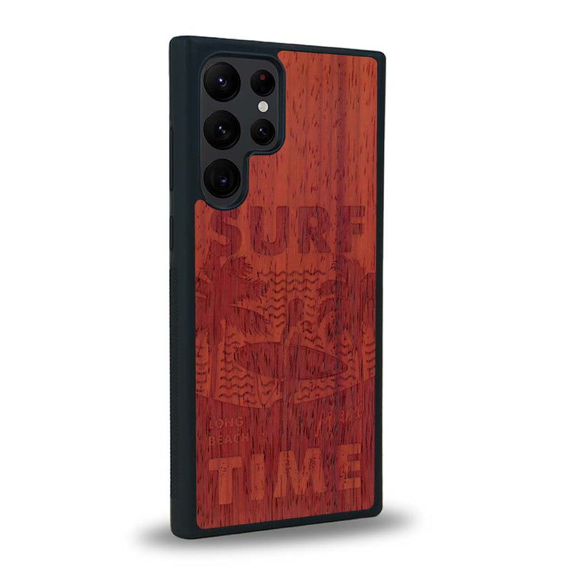 Coque de protection en bois véritable fabriquée en France pour Samsung S24 Ultra sur le thème chill avec un motif représentant une silouhette tenant une planche de surf sur une plage entouré de palmiers et les mots "Surf Time Long Beach Miami"