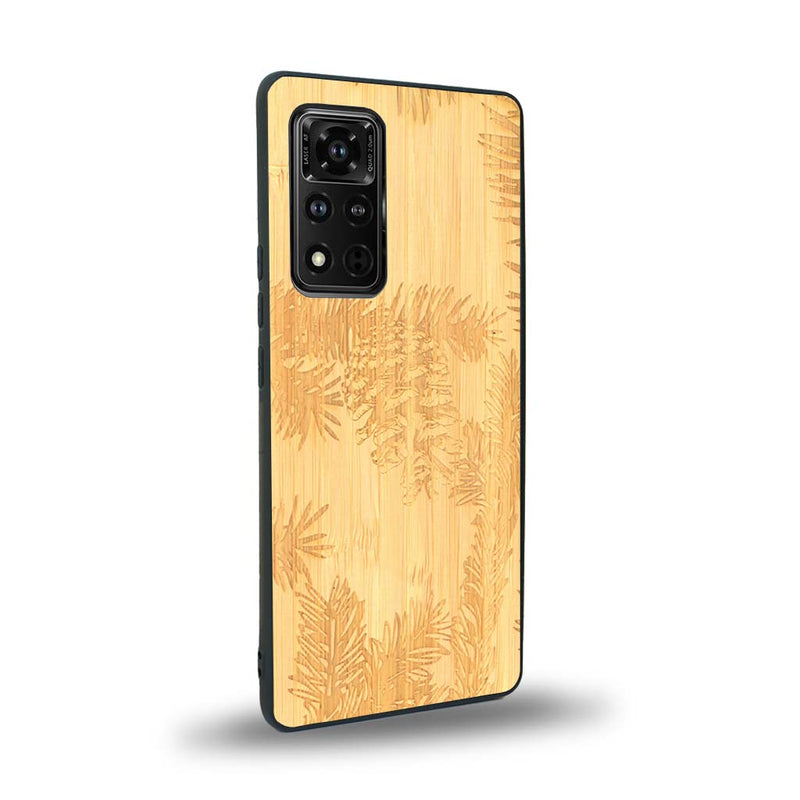 Coque de protection en bois véritable fabriquée en France pour Honor V40 sur le thème de la nature des arbres avec un motif de gravure représentant des épines de sapin et des pommes de pin