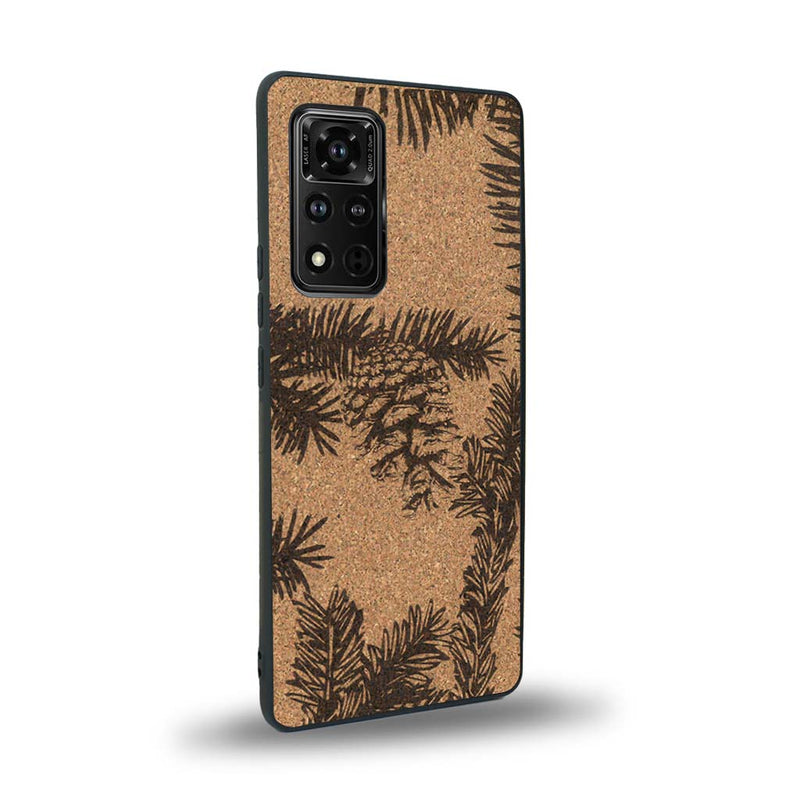 Coque de protection en bois véritable fabriquée en France pour Honor V40 sur le thème de la nature des arbres avec un motif de gravure représentant des épines de sapin et des pommes de pin