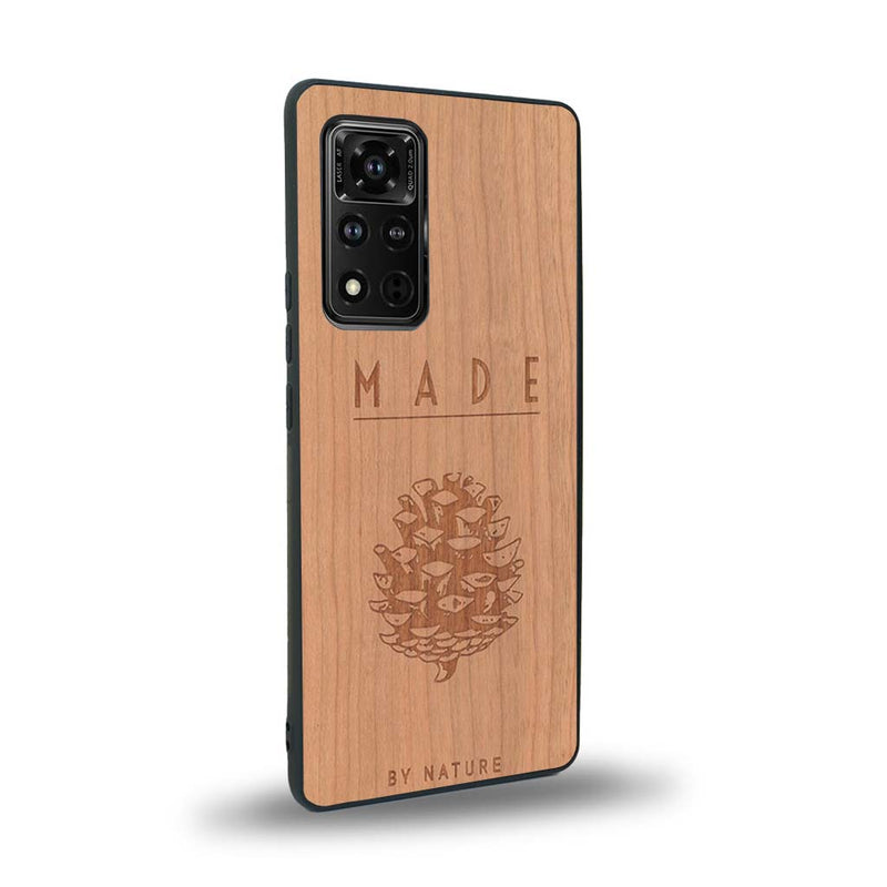 Coque de protection en bois véritable fabriquée en France pour Honor V40 sur le thème de la nature et des arbres avec une gravure représentant une pomme de pin et la phrase "made by nature"