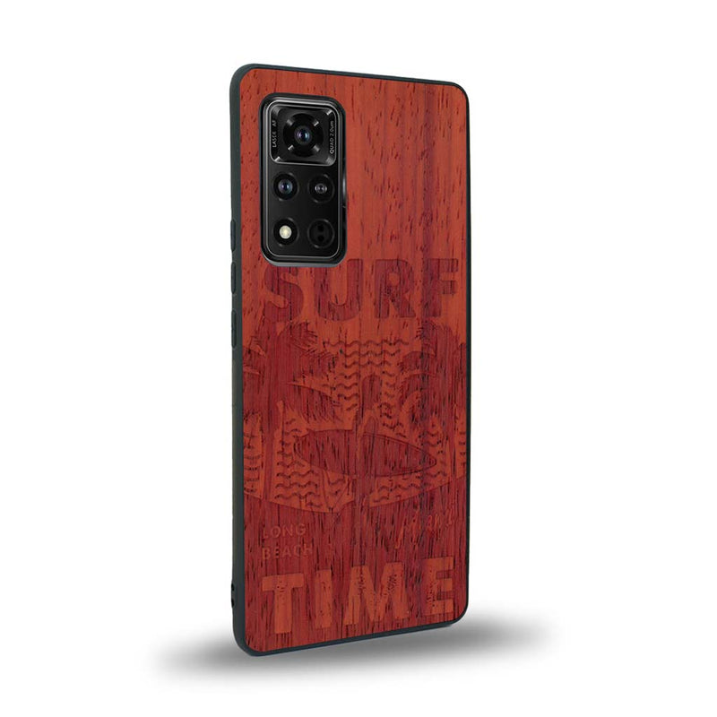 Coque de protection en bois véritable fabriquée en France pour Honor V40 sur le thème chill avec un motif représentant une silouhette tenant une planche de surf sur une plage entouré de palmiers et les mots "Surf Time Long Beach Miami"