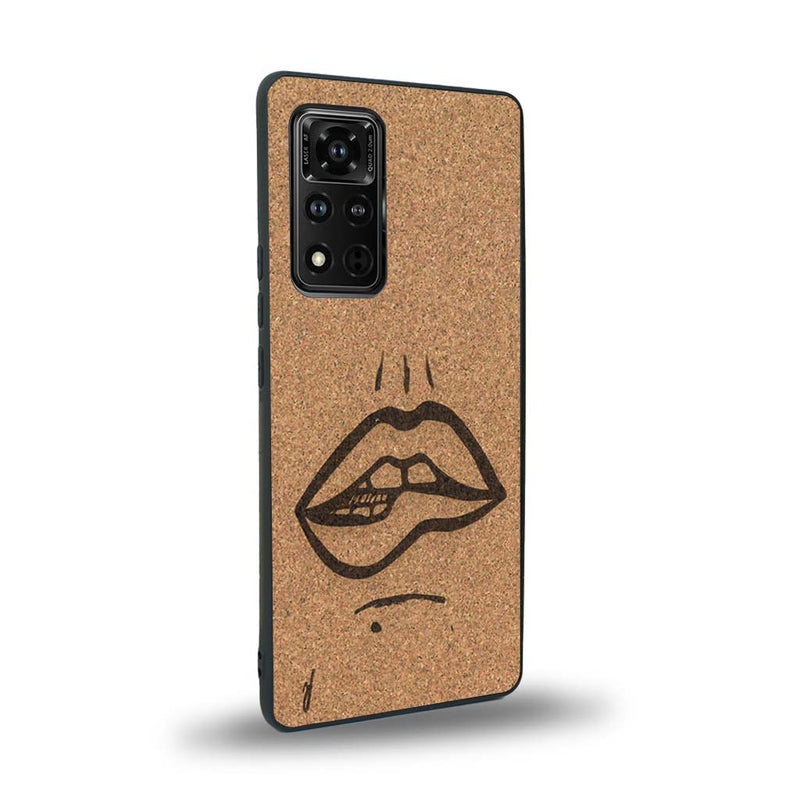 Coque de protection en bois véritable fabriquée en France pour Honor V40 représentant de manière minimaliste une bouche de féminine se mordant le coin de la lèvre de manière sensuelle dessinée à la main par l'artiste Maud Dabs