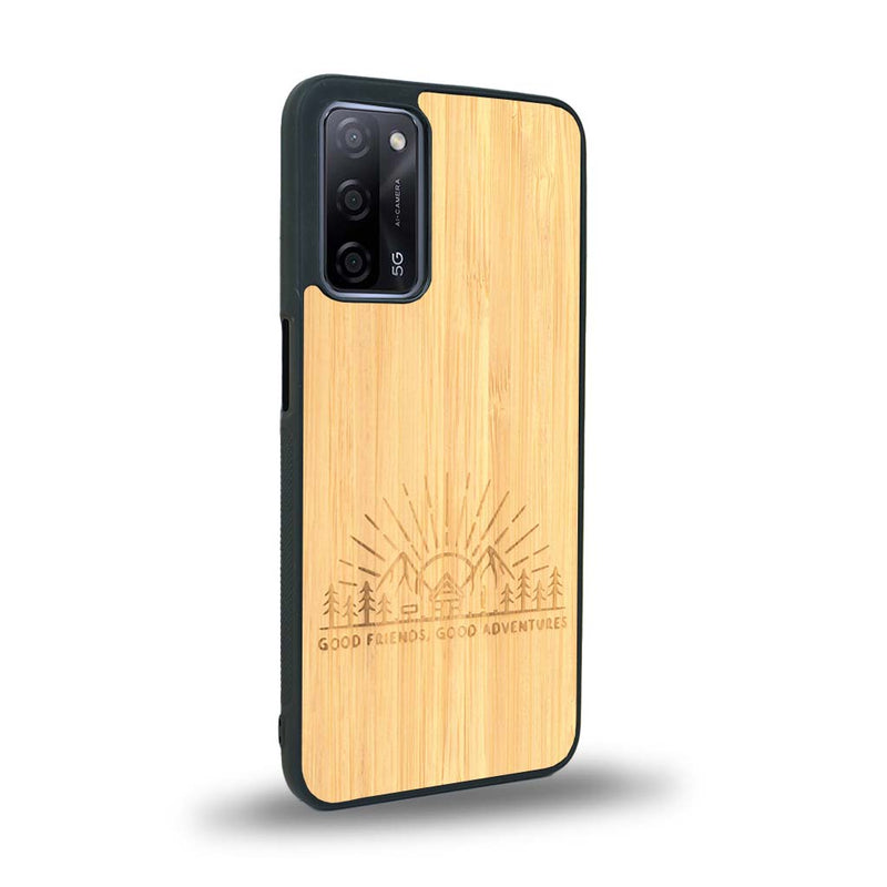 Coque de protection en bois véritable fabriquée en France pour Oppo A55 5G sur le thème chill et nature avec un motif représentant un levé de soleil sur un paysage de montagne avec des sapins et un chalet et la phrase "Good friends, good adventure"