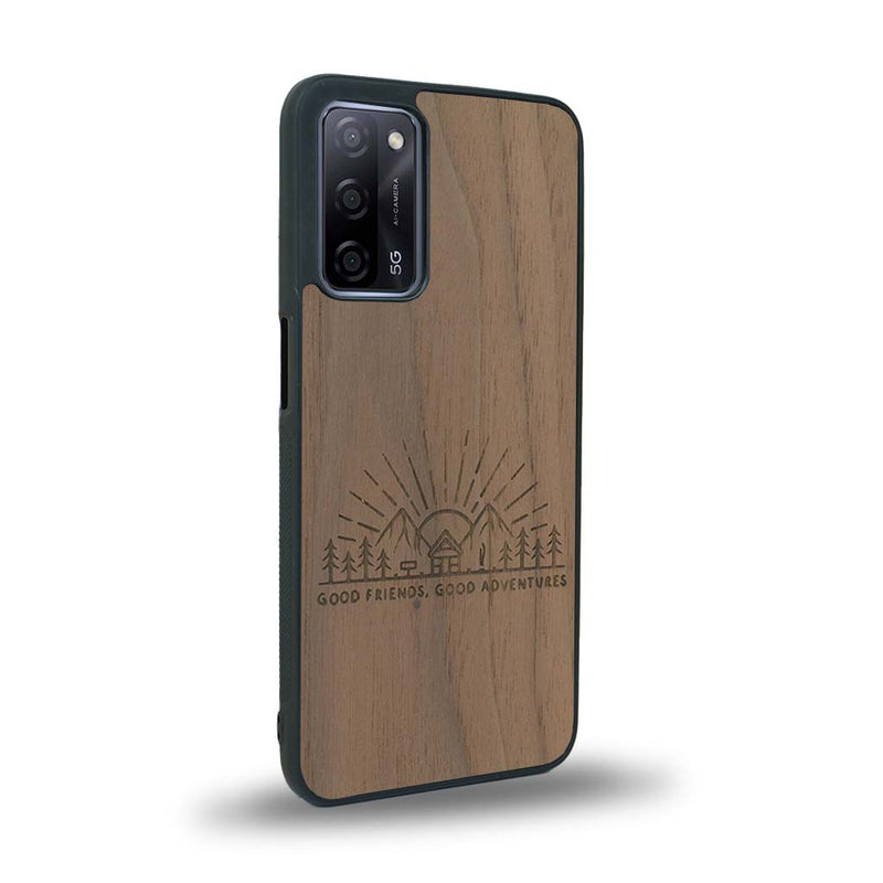 Coque de protection en bois véritable fabriquée en France pour Oppo A55 5G sur le thème chill et nature avec un motif représentant un levé de soleil sur un paysage de montagne avec des sapins et un chalet et la phrase "Good friends, good adventure"