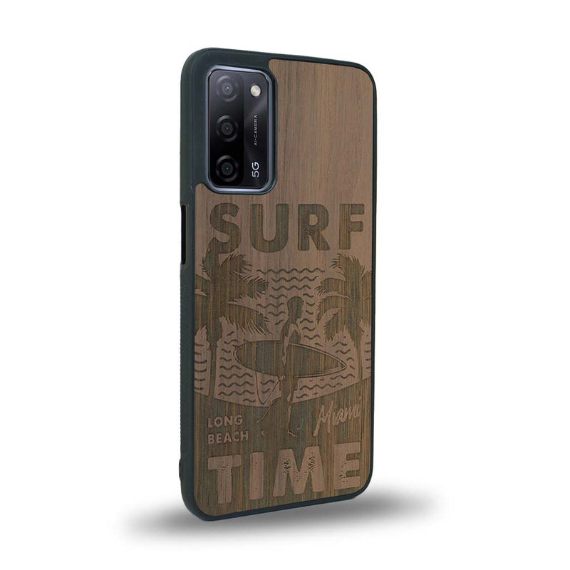 Coque de protection en bois véritable fabriquée en France pour Oppo A55 5G sur le thème chill avec un motif représentant une silouhette tenant une planche de surf sur une plage entouré de palmiers et les mots "Surf Time Long Beach Miami"