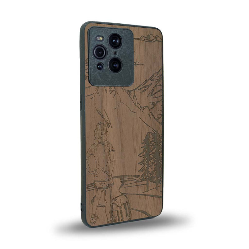 Coque de protection en bois véritable fabriquée en France pour Oppo Find X3 Pro sur le thème de la randonnée en montagne et de l'aventure avec une gravure représentant une femme de dos face à un paysage de nature