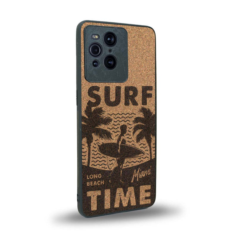 Coque de protection en bois véritable fabriquée en France pour Oppo Find X3 Pro sur le thème chill avec un motif représentant une silouhette tenant une planche de surf sur une plage entouré de palmiers et les mots "Surf Time Long Beach Miami"