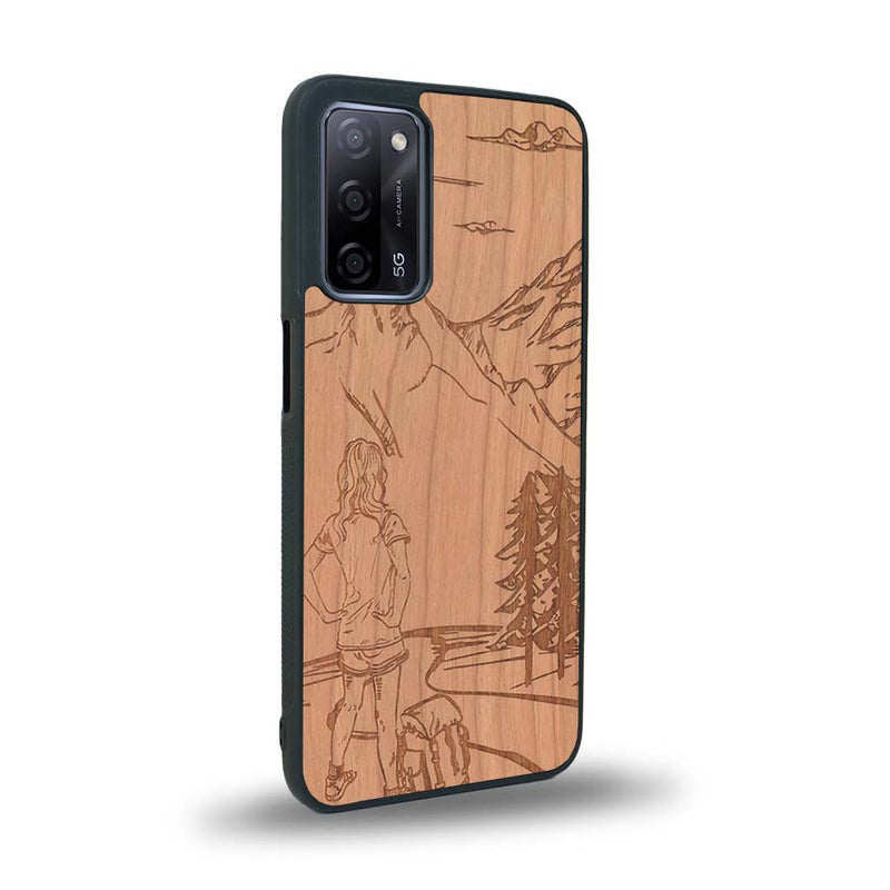 Coque de protection en bois véritable fabriquée en France pour Oppo Reno 4 sur le thème de la randonnée en montagne et de l'aventure avec une gravure représentant une femme de dos face à un paysage de nature