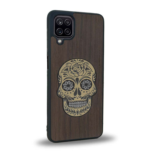 Coque de protection en bois véritable fabriquée en France pour Samsung A12 alliant du chêne fumé avec du métal argenté et doré représentant une tête de mort mexicaine sur le thème Dia de los Muertos