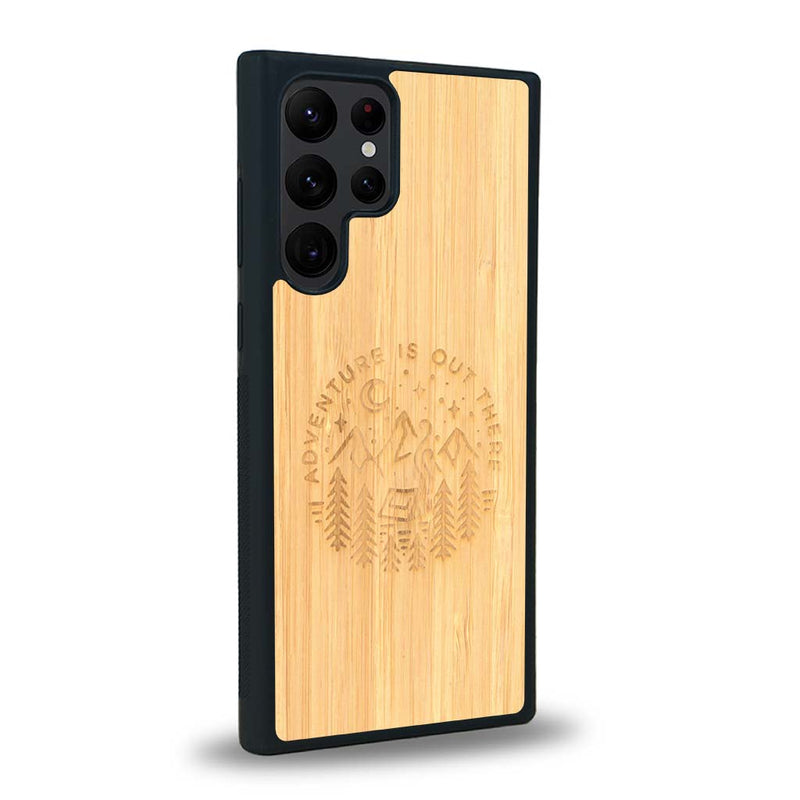 Coque de protection en bois véritable fabriquée en France pour Samsung S23 Ultra sur le thème du camping en pleine nature et du bivouac avec la phrase "Aventure is out there"