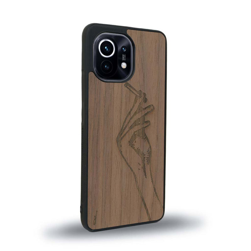 Coque de protection en bois véritable fabriquée en France pour Xiaomi Mi 11 représentant une main de femme tenant une cigarette de type line art en collaboration avec l'artiste Maud Dabs