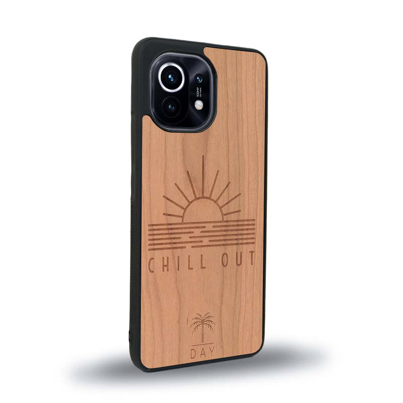 Coque de protection en bois véritable fabriquée en France pour Xiaomi Mi 11 Lite sur le thème chill avec un motif représentant un couché de soleil sur l'océan et la phrase "Chill out"