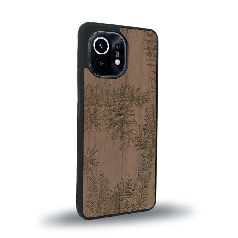 Coque de protection en bois véritable fabriquée en France pour Xiaomi Mi 11 Lite sur le thème de la nature des arbres avec un motif de gravure représentant des épines de sapin et des pommes de pin