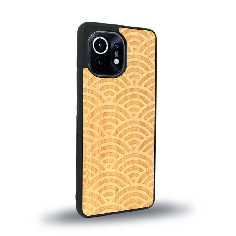 Coque de protection en bois véritable fabriquée en France pour Xiaomi Mi 11 Lite baptisée "La Sinjak" avec un motif de gravure abstrait représentant la répétition d'un symbole wifi