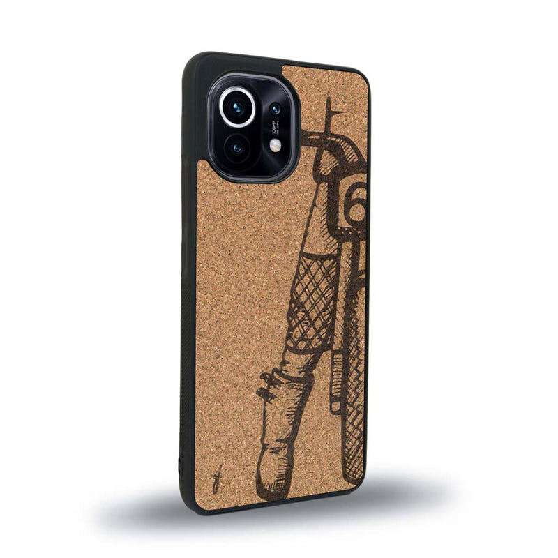 Coque de protection en bois véritable fabriquée en France pour Xiaomi Mi 11 Lite représentant une vue de face d'une femme sur une moto vintage dessinée à la main par l'artiste Maud Dabs