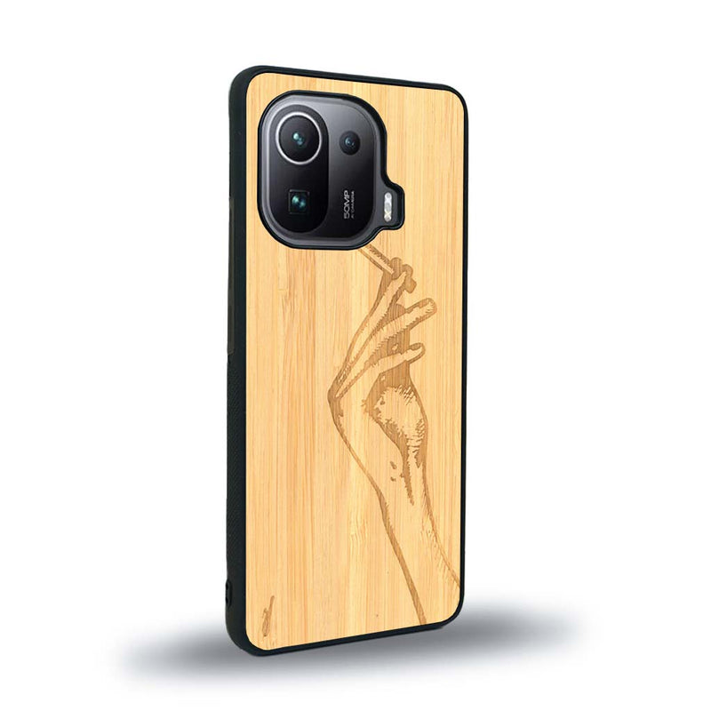 Coque de protection en bois véritable fabriquée en France pour Xiaomi Mi 11 Ultra représentant une main de femme tenant une cigarette de type line art en collaboration avec l'artiste Maud Dabs