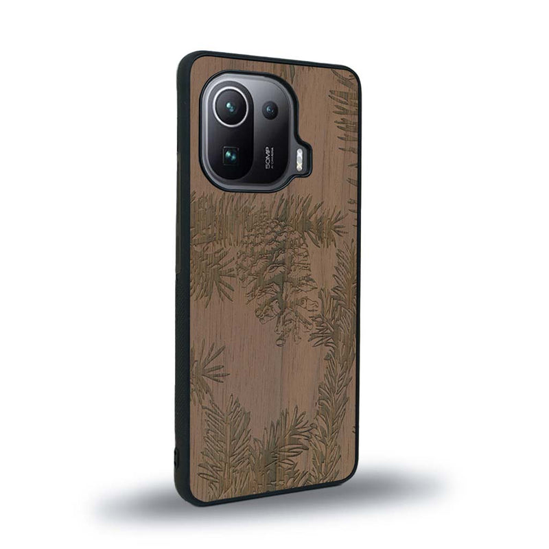 Coque de protection en bois véritable fabriquée en France pour Xiaomi Mi 11 Ultra sur le thème de la nature des arbres avec un motif de gravure représentant des épines de sapin et des pommes de pin